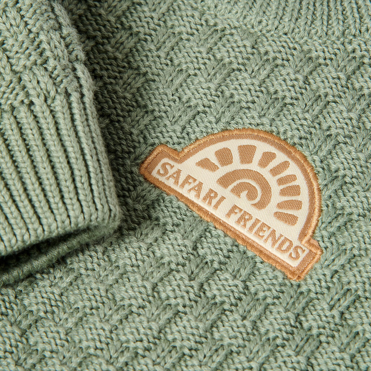Gestrickter Pullover grün mit Aufnäher
