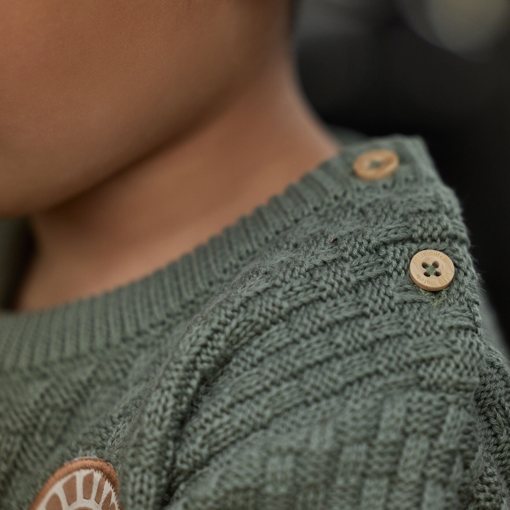 Gestrickter Pullover grün mit Aufnäher